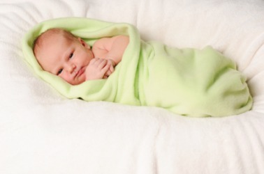 A baby wrapped in a receiving blanket. A baby wrapped in a receiving blanket.