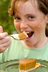 A girl about to taste some pumpkin pie. A girl about to taste some pumpkin pie.