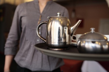 A waitress carrying a tea tray. A waitress carrying a tea tray.