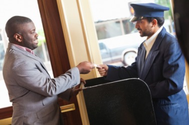 A hotel valet assists a guest. A hotel valet assists a guest.