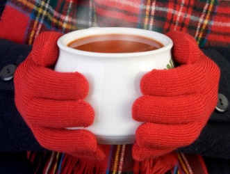 A girl uses a cup of soup to warm her hands. A girl uses a cup of soup to warm her hands.