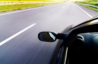 A car zooms down the road. A car zooms down the road.