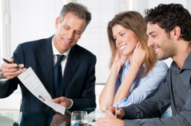 A couple discuss their finances with a banker. A couple discuss their finances with a banker.