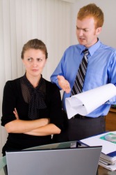 This woman is annoyed by her bossy co-worker. This woman is annoyed by her bossy co-worker.