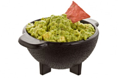 A bowl filled to the brim with guacamole. A bowl filled to the brim with guacamole.