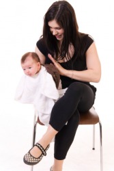 A mother tries to get her baby to burp. A mother tries to get her baby to burp.