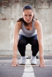 A woman in the process of performing a burpee. A woman in the process of performing a burpee.
