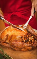 A woman carves the Thanksgiving turkey. A woman carves the Thanksgiving turkey.