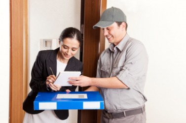 A woman accepts delivery of a package. A woman accepts delivery of a package.