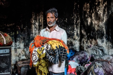 A dhobi with an arm full of laundry. A dhobi with an arm full of laundry.