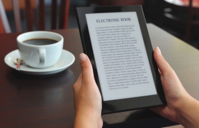 A woman using an e-reader. A woman using an e-reader.