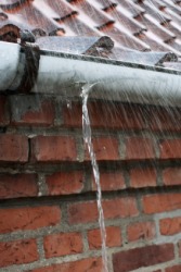 A gutter with a leak. A gutter with a leak.