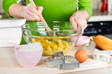 A woman manually mixing a batch of cookies. A woman manually mixing a batch of cookies.