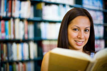 A woman has gone to the library to read up on a subject. A woman has gone to the library to read up on a subject.