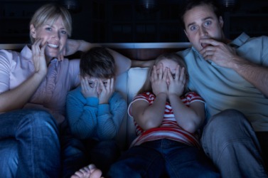 A family watching a scary movie. A family watching a scary movie.